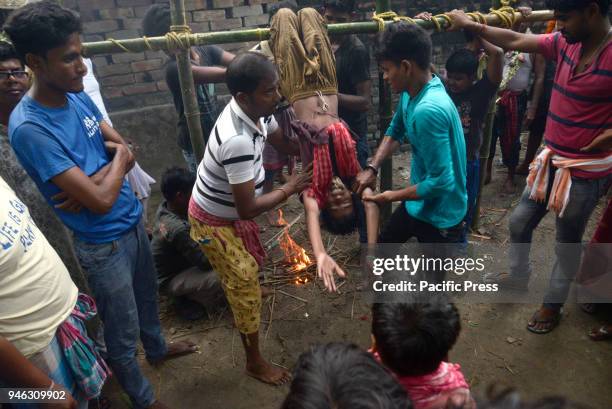 Hindu devotees perform rituals at holy pole during the Charak Puja festival. Bengali observes Charak Puja on the last day of Bengali calendar...