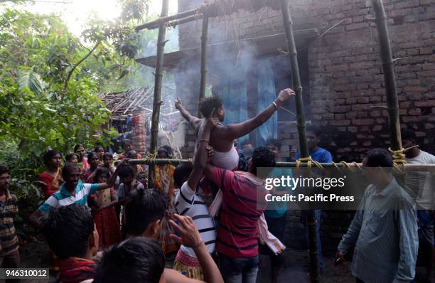 Hindu devotees perform rituals at holy pole during the Charak Puja festival. Bengali observes Charak Puja on the last day of Bengali calendar...