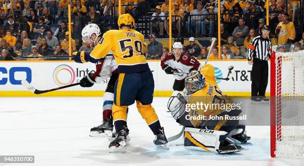 Gabriel Landeskog of the Colorado Avalanche tips the puck over the glove of Pekka Rinne of the Nashville Predators for a goal as Roman Josi defends...
