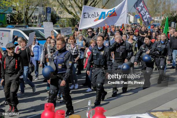 Riot police officers escort the protest march through Flörsheim. People from different political organisations and trade unions protested outside the...