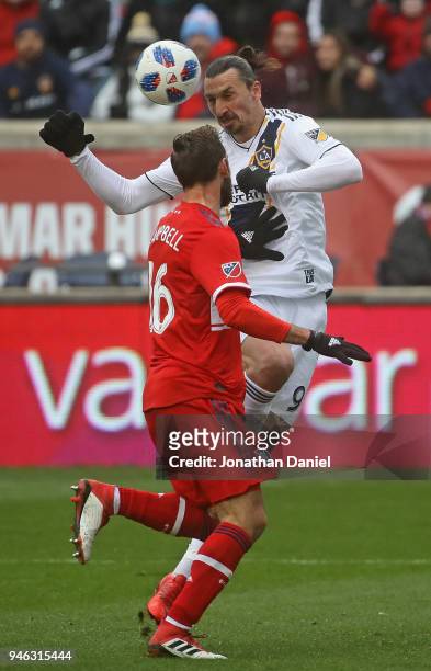 Zlatan Ibrahimovic of Los Angeles Galaxy heads the ball over Jonathan Campbell of Chicago Fire at Toyota Park on April 14, 2018 in Bridgeview,...