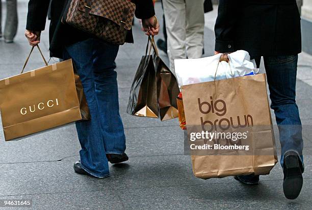 David Benjamin, left, carries shopping bags including a Gucci bag,and Paolo Presta, right, also carries shopping bags, including a "big brown bag"...