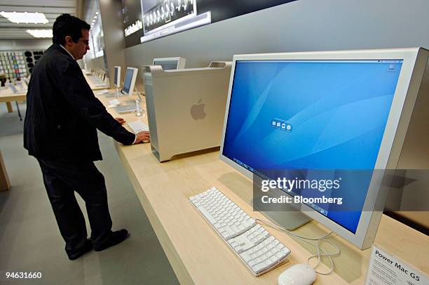 Inch Apple Cinema HD Display sits on display as John Perugini looks over a Power Mac G5 nearby during a preview of the new Apple Store in New York,...