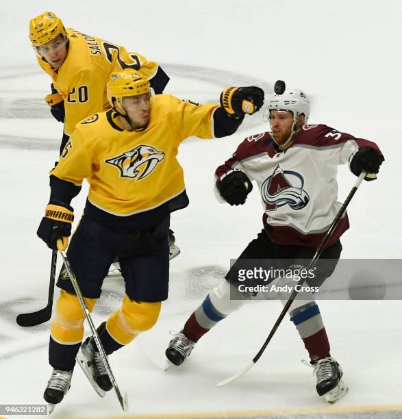 Nashville Predators defenseman Alexei Emelin advances the puck with his hand against Colorado Avalanche left wing J.T. Compher in the first period...