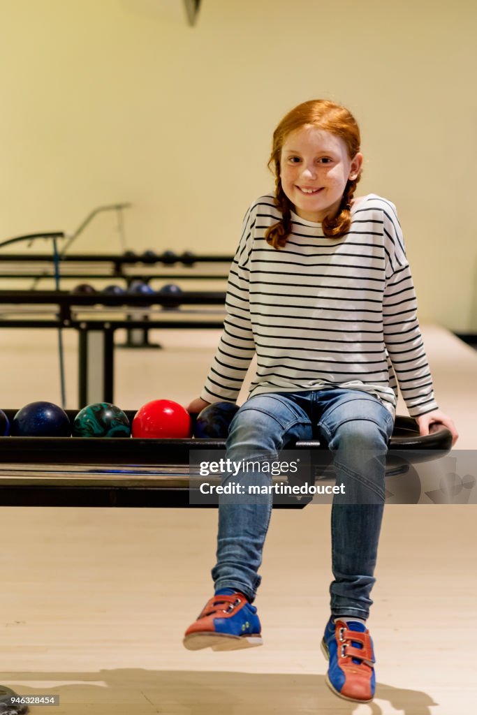 Retrato de niña preadolescente Linda pelirroja jugando bowling.