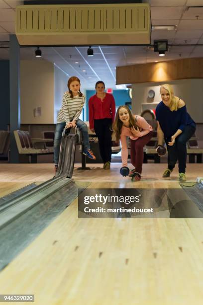 mother, daughter and friends playing bowling. - bowling alley stock pictures, royalty-free photos & images
