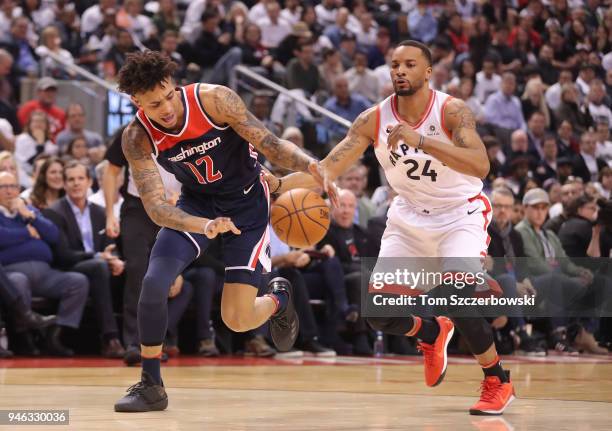 Kelly Oubre Jr. #12 of the Washington Wizards tries to control the ball as he goes to the basket past Norman Powell of the Toronto Raptors in the...