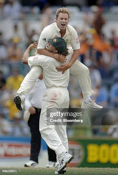 Australian bowler Shane Warne leaps into the arms of teammate Andrew Symonds, after claiming the final wicket of England batsman Monty Panesar, to...