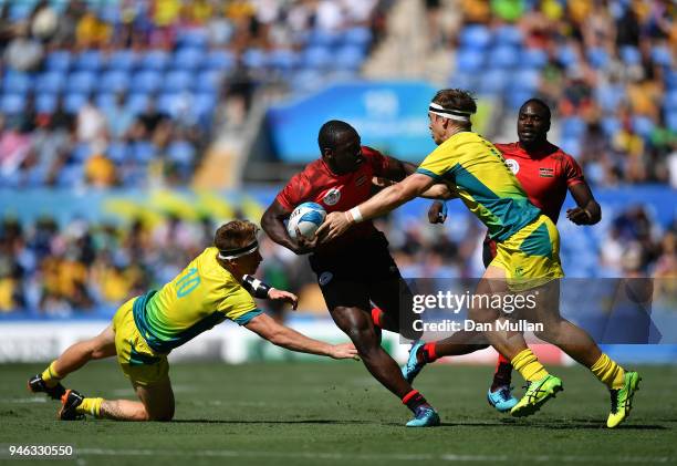 Billy Odhiambo of Kenya takes on Ben O'Donnell and Charlie Taylor of Australia during the Rugby Sevens Men's Placing 5-8th match between Australia...