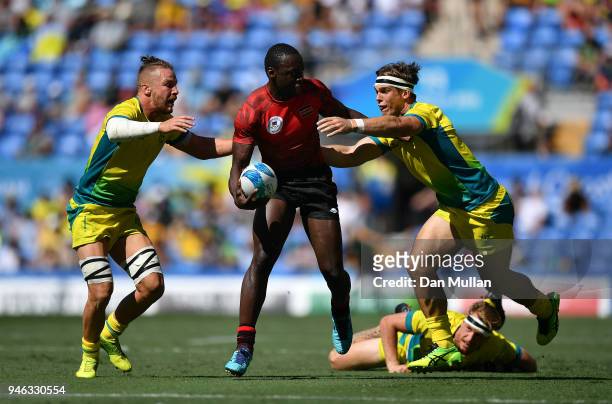 Billy Odhiambo of Kenya takes on Ben O'Donnell and Charlie Taylor of Australia during the Rugby Sevens Men's Placing 5-8th match between Australia...