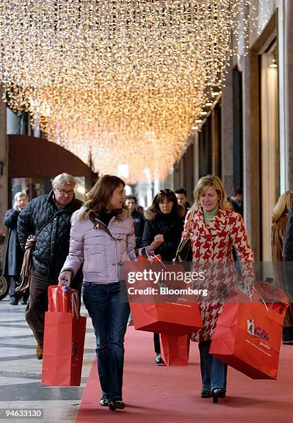 Women carry shopping bags full of Christmas gifts at a shopping center in Milan, Italy, on Tuesday, Dec. 18, 2007. The pace of Italian consumer...