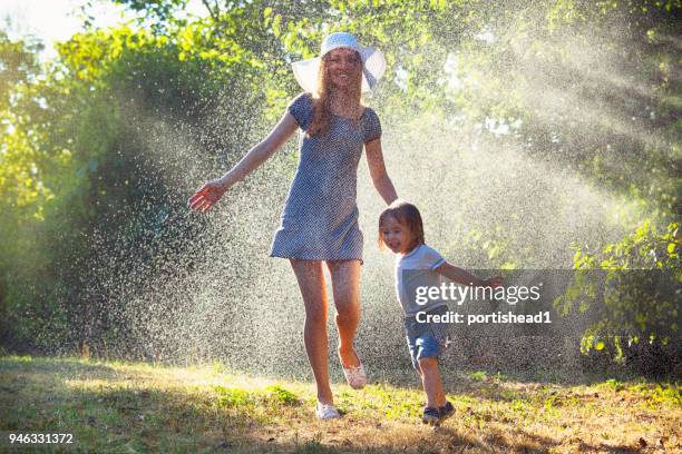 mutter und kind spaß im regen - brother sister shower stock-fotos und bilder