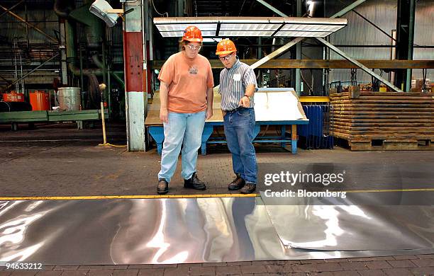 Judy Borst, left, and Mike Wood inspect a roll of aluminum during processing in the Alcoa Warrick Operations plant in Boonville, Indiana, Tuesday,...