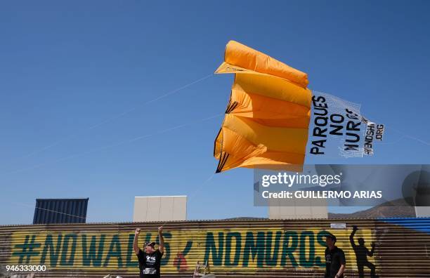 Activists fly a kite over the US-Mexico border wall, as part of the "Picnic prototype, Security through Friendship" activity at the border near US...