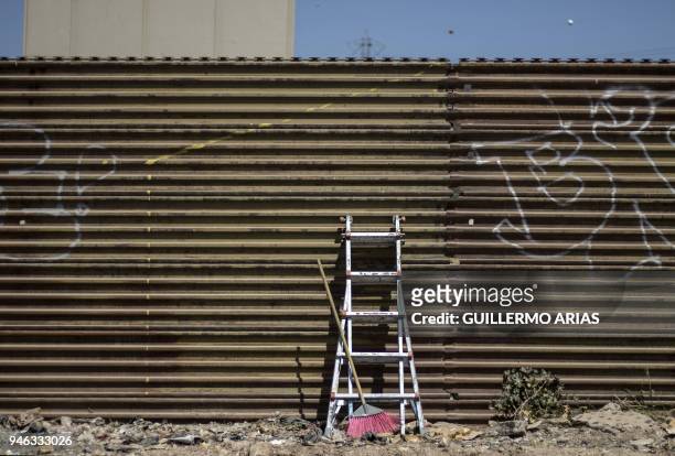 Ladder and broom lean against the US-Mexico border wall, as part of the "Picnic prototype, Security through Friendship" activity at the border near...