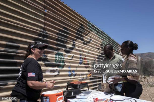 People share a picnic beside the US-Mexico border wall, as part of the "Picnic prototype, Security through Friendship" activity at the border near US...