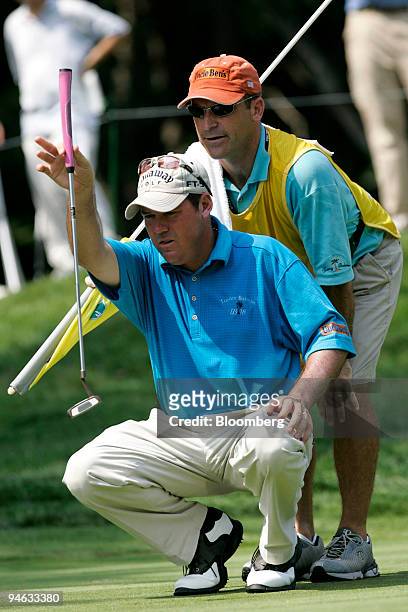 Golfer Rich Beem, left, is assisted by his caddy as he lines up a putt on the 4th green during the Barclays Classic golf tournament at Westchester...