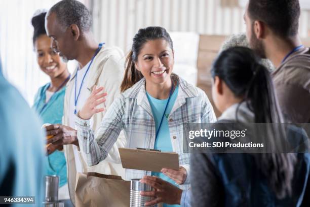 food bank manager organizes group of volunteers - homeless shelter stock pictures, royalty-free photos & images