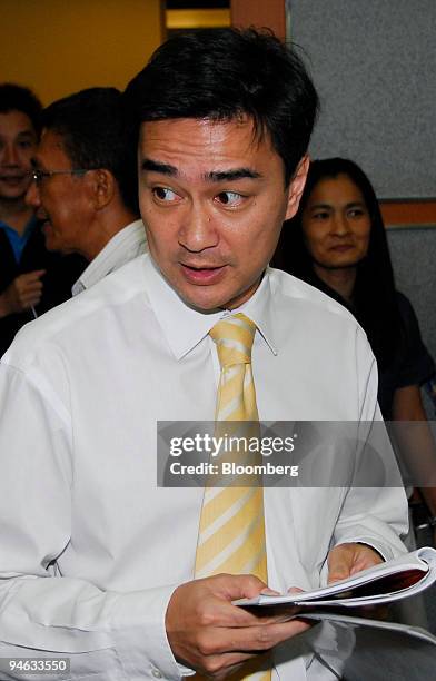 Abhisit Vejjajiva, leader of the Democrat Party, speaks with a party executive at the party's headquarters, in Bangkok, Thailand, on Tuesday, June...