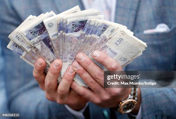 Racegoer holds his winnings on day two 'Ladies Day' of The Randox Health Grand National Festival at Aintree Racecourse on April 13, 2018 in...