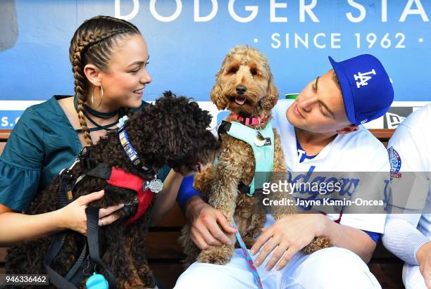 Enrique Hernandez of the Los Angeles Dodgers and his wife Mariana Hernandez, hold their dogs Arizona and Bruce Wayne, in the dugout during "Pups at...
