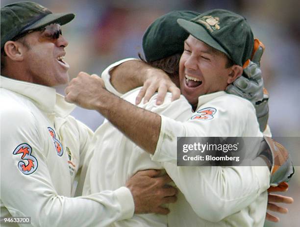 Australia's Matthew Hayden, left, and Adam Gilchrist, center, rush to captain Ricky Ponting, right, after claiming the final winning wicket off...