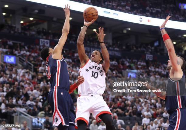 DeMar DeRozan of the Toronto Raptors shoots and scores a basket over Otto Porter Jr. #22 of the Washington Wizards in the third quarter during Game...
