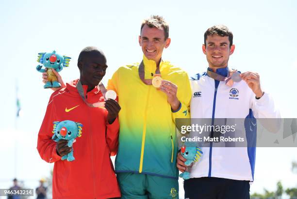 Silver medalist Munyo Solomon Mutai of Uganda, gold medalist Michael Shelley of Australia and bronze medalist Robbie Simpson of Scotland celebrate...