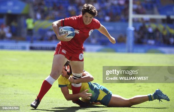 Canada's Brittany Benn is tackled by an Australian defender Charlotte Caslick in their women's rugby sevens semi-final match at the Robina Stadium...