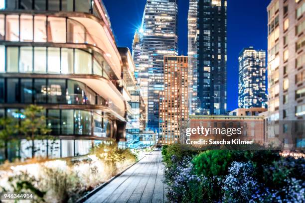 brightly lit buildings along the high line at night - meatpacking district stock pictures, royalty-free photos & images