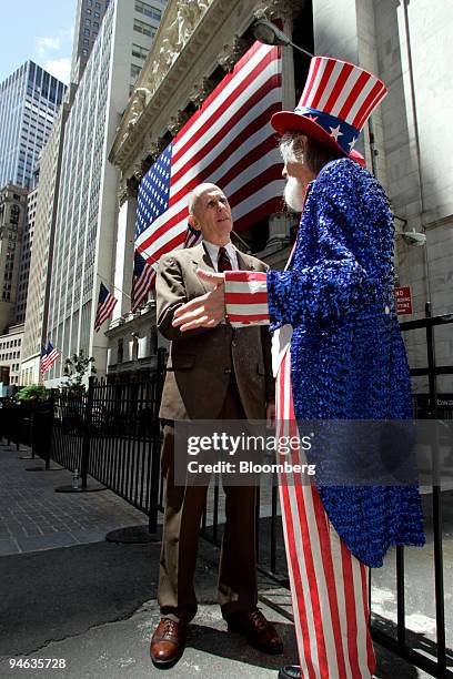 An actor playing "Uncle Sam" talks with a fictitious Sam Walton, founder of Wal-Mart, during a street theater performance outside the New York Stock...