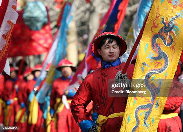 Performer dressed in a Qing dynasty court costume carries a banner during a ceremony at the Ditan Temple Fair for Lunar New Year, in Beijing, China,...