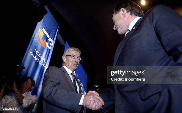 Nick Minchin, Australian Minister of Finance and Administration, left, and Donald McGauchie, chairman of Telstra, shake hands following the media...