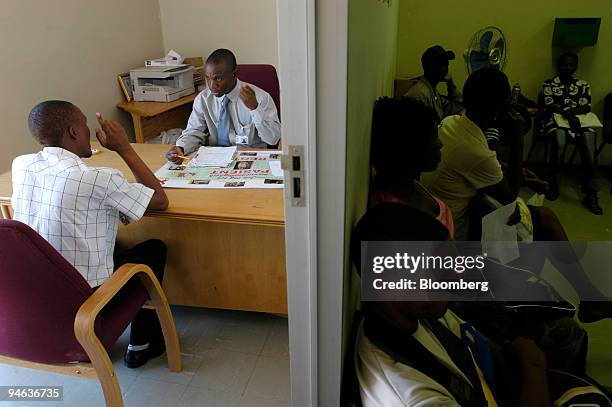 Pharmacist, left, explains to a patient how to take an array of antiretroviral drugs while other patients queue for treatment, at Nthabiseng Clinic,...