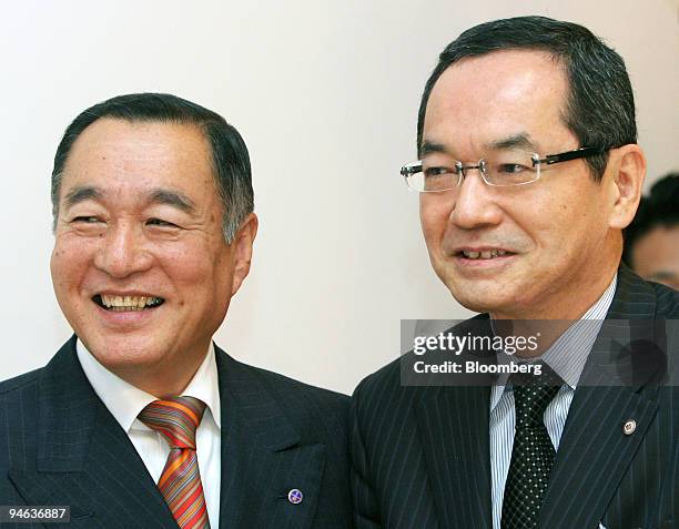 Nobukazu Muto, president of Isetan Co., left, and Kunio Ishizuka, president of Mitsukoshi Ltd., smile following a joint news conference in Tokyo,...