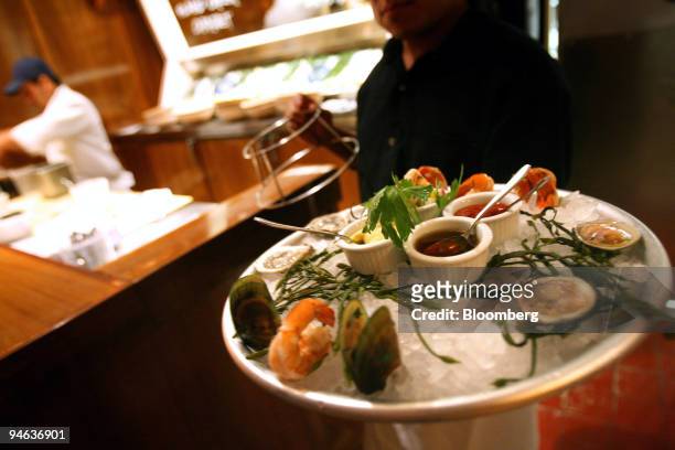 Sampler platter is held up by a waitress at Lure Fishbar, a seafood restaurant in the SoHo area of New York on Monday, May 22, 2006.