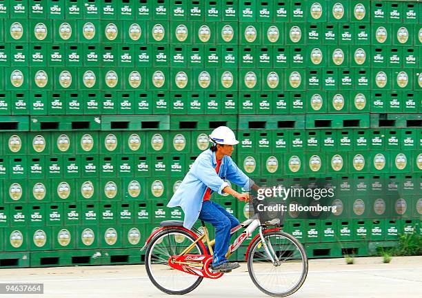 Worker cycles past beer crates at a Thai Beverage Plc Chang brewery in Kamphaeng Phet, north of Bangkok on Monday, May 22, 2006. Shares of Thai...