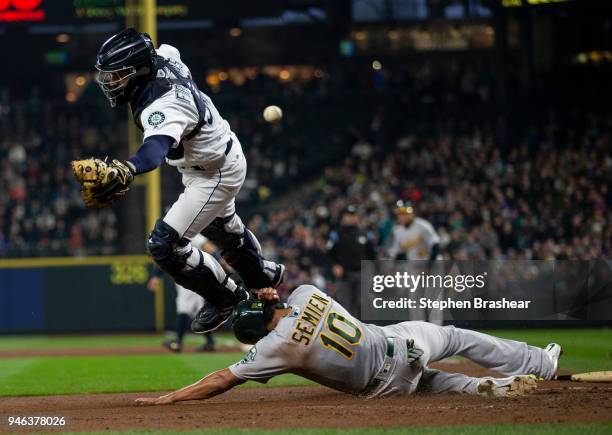 Marcus Semien of the Oakland Athletics scores as catcher cannot get to a throw at the plate on a two-run single by Mark Canha of the Oakland...