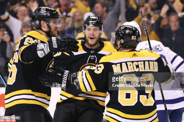 Kevan Miller of the Boston Bruins celebrates with David Pastrnak and Brad Marchand after scoring a goal against the Toronto Maple Leafs during the...