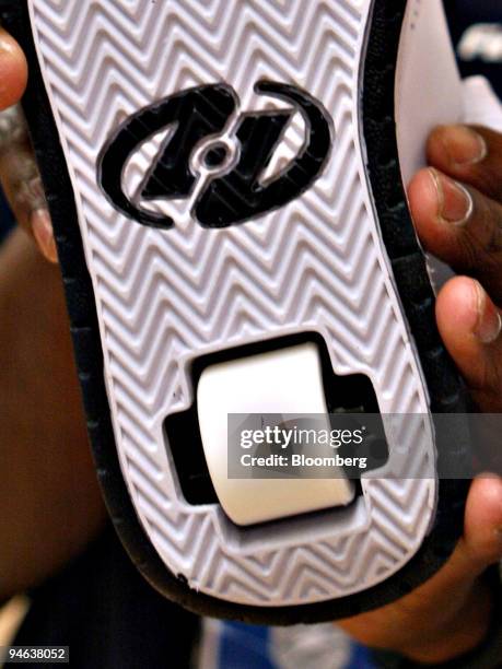 Heelys sneaker is held for a photograph by The Finish Line employee Byron Wesson in Dallas, Texas, Friday, December 8, 2006.