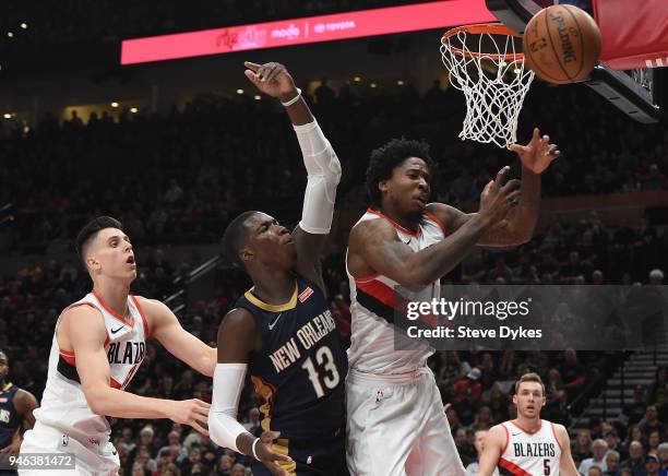Ed Davis of the Portland Trail Blazers and Cheick Diallo of the New Orleans Pelicans battle for a rebound as Zach Collins of the Portland Trail...