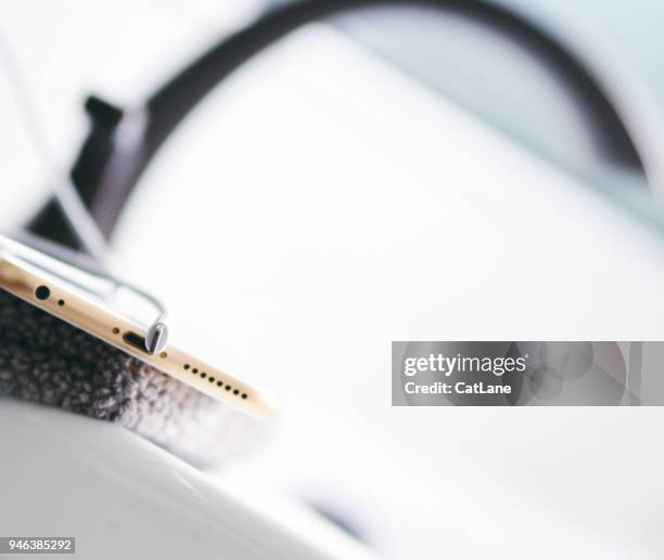 iphone 6s plus with charging cable on the side of a bathtub - iphone 6s imagens e fotografias de stock