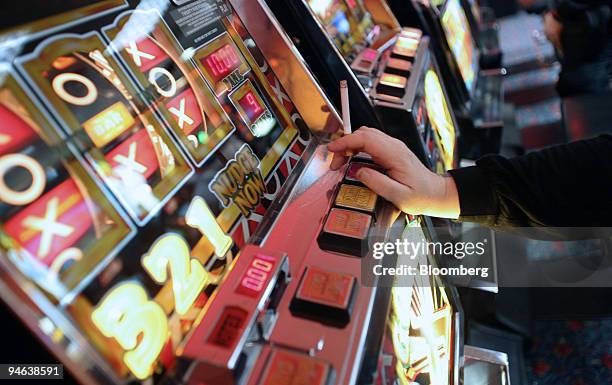 Woman smokes while playing slot machines at Beacon Bingo in Cricklewood Broadway, north London, on Wednesday, December 13, 2006. Bingo parlors, once...