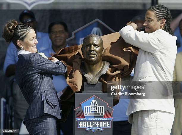 Sara White, left, wife of late Hall of Fame inductee Reggie White, and their son Jeremy unveil a bust of Reggie White during his induction into the...