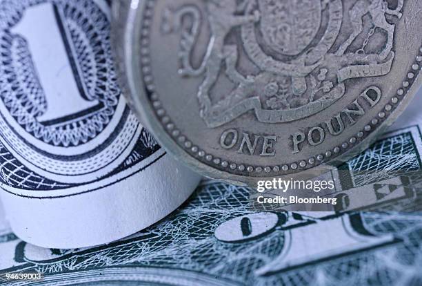 One British pound coin and two U.S. Dollars are seen in London, U.K. Friday, April 20, 2007. The dollar fell to the lowest in two months against the...