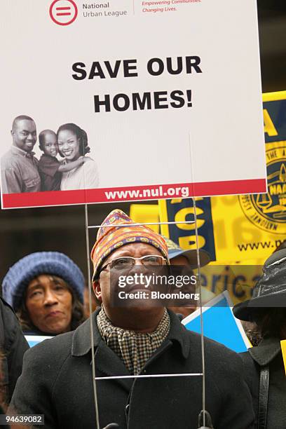Man marches with a sign during a rally to call for a corporate response to the rise in home foreclosures, in the Wall Street district of New York,...