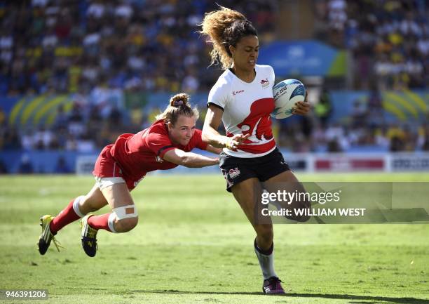 England's Deborah Fleming is tackled by Canada's Julia Greenshields in the women's rugby sevens bronze medal match at the Robina Stadium during the...