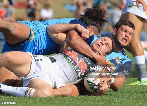 James Maloney of the Panthers is tackled by Ash Taylor and Konrad Hurrell of the Titans during the round six NRL match between the Penrith Panthers...