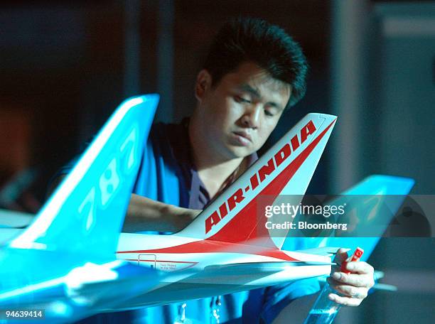 An attendant puts cleaning touches to miniature of Boeing 747-8 planes at an exhibition during the Aero India 2007 in Bangalore, India, on Friday,...