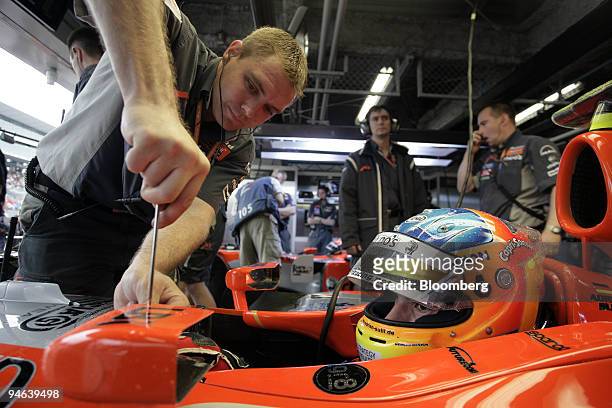 Mechanic for the Spyker MF1 team fixes the mirror on Adrian Sutil's car during the first practice day for the Formula 1 Japanese Grand Prix in...